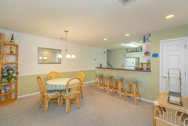 dining room featuring light colored carpet, a textured ceiling, and an inviting chandelier