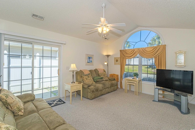 carpeted living room featuring visible vents, a ceiling fan, a textured ceiling, and lofted ceiling
