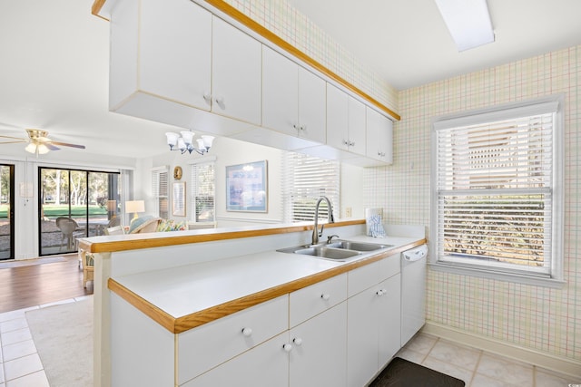 kitchen featuring a sink, dishwasher, open floor plan, wallpapered walls, and light countertops