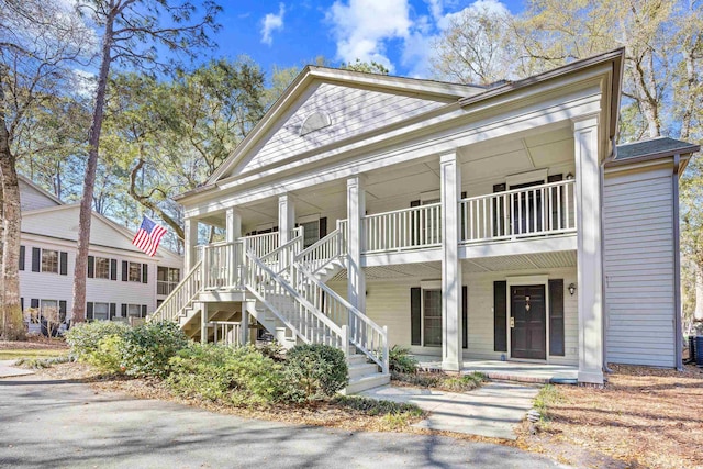 greek revival house featuring a porch and stairs