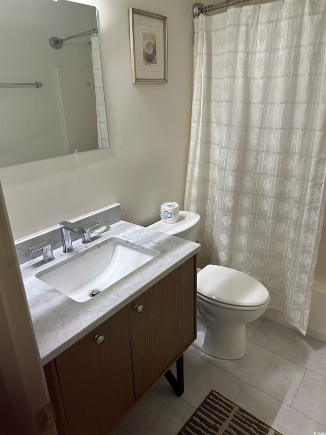 bathroom featuring toilet, vanity, tile patterned flooring, and shower / bath combo