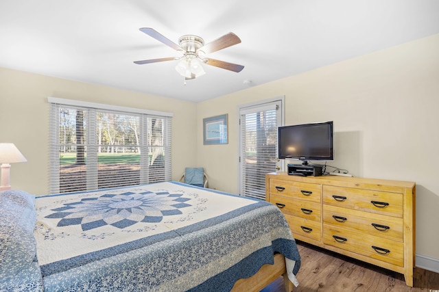 bedroom featuring multiple windows, wood finished floors, and a ceiling fan