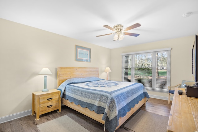 bedroom with baseboards, wood finished floors, and a ceiling fan