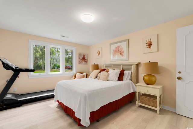 bedroom featuring baseboards, visible vents, and light wood-style flooring