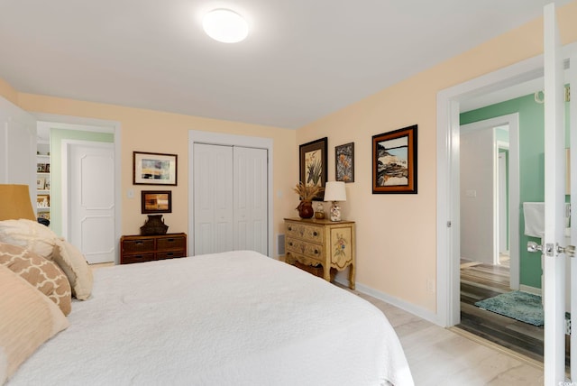 bedroom with a closet, light wood finished floors, and baseboards