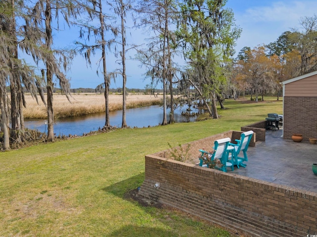view of yard featuring a patio area and a water view