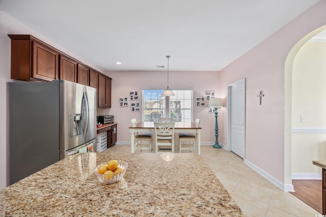 1112 Raven Cliff Ct, Conway, SC 29526 - kitchen featuring arched walkways, stainless steel refrigerator with ice dispenser, light tile patterned flooring, light stone counters, and decorative light fixtures