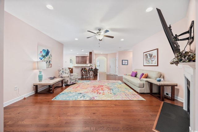 1112 Raven Cliff Ct, Conway, SC 29526 - living area featuring ceiling fan, a fireplace with flush hearth, dark wood-style floors, baseboards, and arched walkways