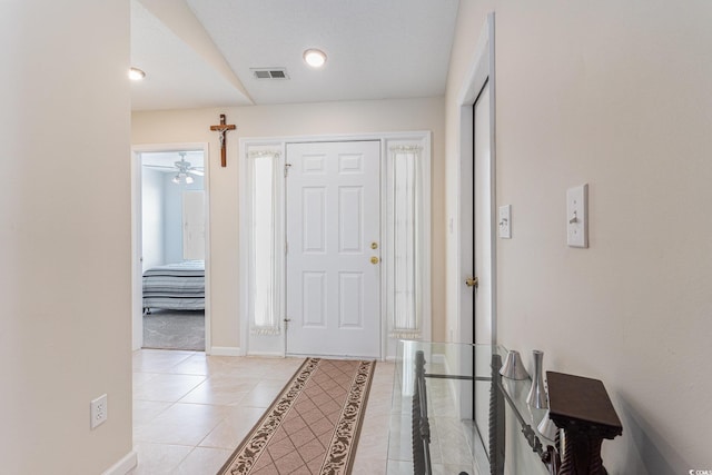 foyer entrance with light tile patterned floors, baseboards, and ceiling fan