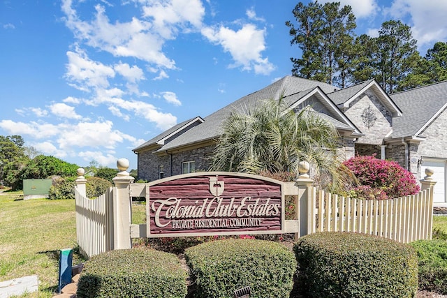 community sign featuring a yard and a garage