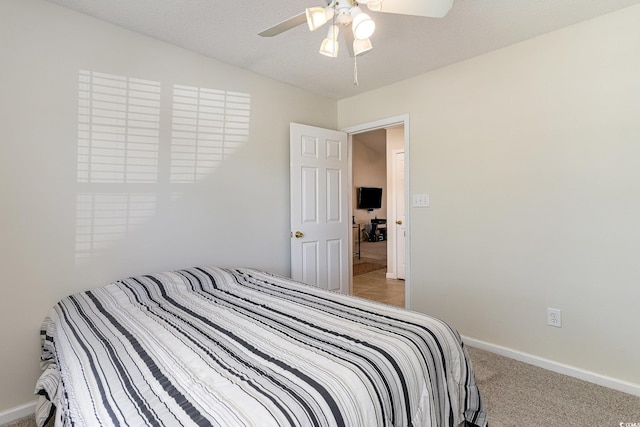 bedroom featuring baseboards, light carpet, and a ceiling fan
