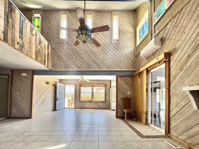 613 23rd Ave N, North Myrtle Beach, SC 29582 - unfurnished living room featuring a ceiling fan, wood walls, a high ceiling, a wall mounted AC, and plenty of natural light