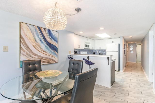707 S Ocean Blvd Unit 602, North Myrtle Beach, SC 29582 - dining space featuring a chandelier, a textured ceiling, recessed lighting, and baseboards