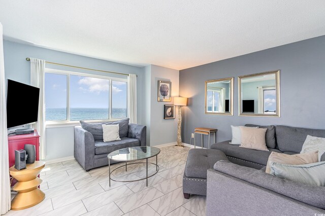 707 S Ocean Blvd Unit 602, North Myrtle Beach, SC 29582 - living area featuring light marble finish flooring, baseboards, and a textured ceiling