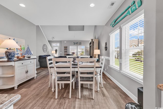 dining area with light wood finished floors, baseboards, visible vents, and a healthy amount of sunlight