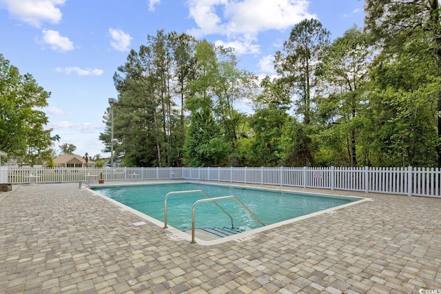 community pool with fence and a patio