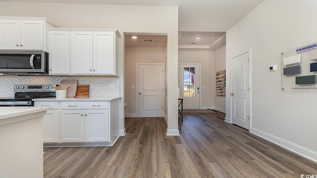 kitchen with white cabinetry, visible vents, wood finished floors, stainless steel appliances, and decorative backsplash