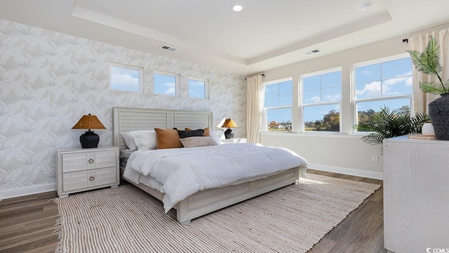 bedroom with baseboards, wallpapered walls, and a raised ceiling