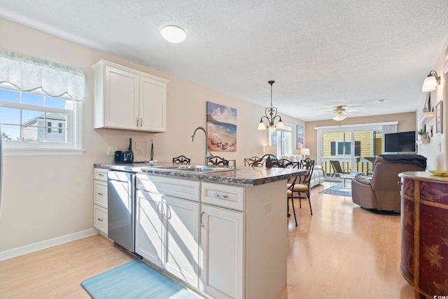 1425 N Waccamaw Dr Unit 123, Garden City Beach, SC 29576 - kitchen featuring dishwasher, a sink, a peninsula, plenty of natural light, and a textured ceiling