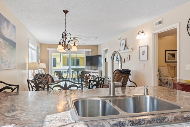 1425 N Waccamaw Dr Unit 123, Garden City Beach, SC 29576 - kitchen with a sink, open floor plan, a textured ceiling, pendant lighting, and a ceiling fan