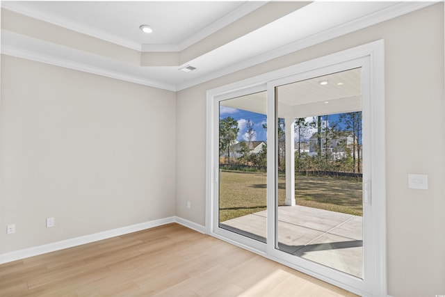 spare room with light wood-type flooring, recessed lighting, ornamental molding, baseboards, and a tray ceiling