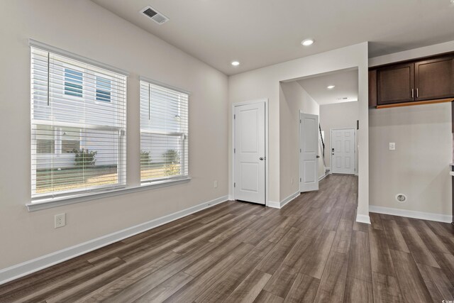 unfurnished living room featuring dark wood-style floors, baseboards, and recessed lighting