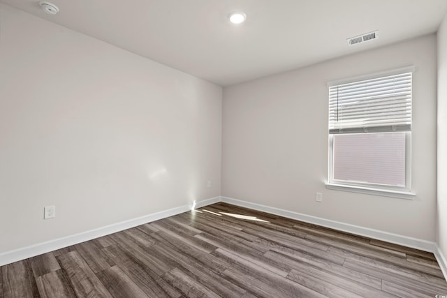unfurnished room featuring a smoke detector, wood finished floors, baseboards, and recessed lighting