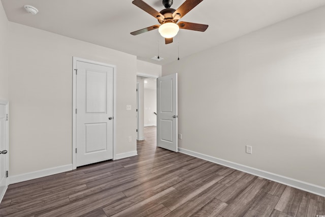 unfurnished bedroom with wood finished floors, baseboards, and a ceiling fan