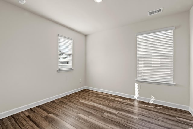 empty room featuring wood finished floors and baseboards