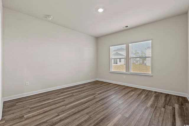 unfurnished room with dark wood-type flooring and baseboards