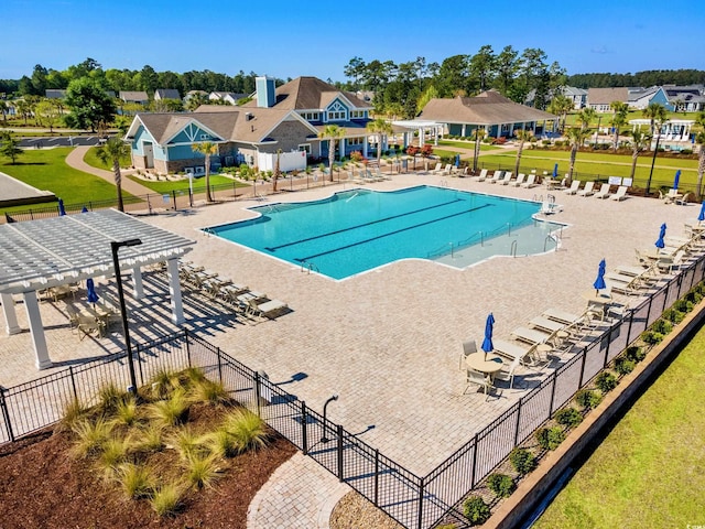 community pool featuring fence, a pergola, and a patio