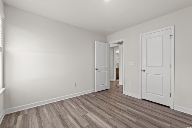 unfurnished bedroom with wood finished floors and baseboards