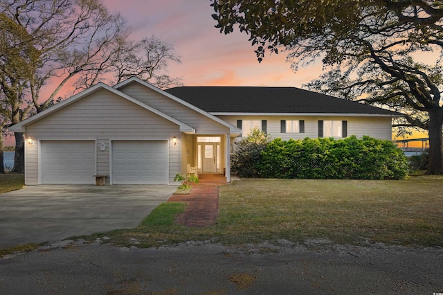 110 Hickory St, Sunset Beach, NC 28468 - view of front of house featuring a lawn, a garage, and concrete driveway