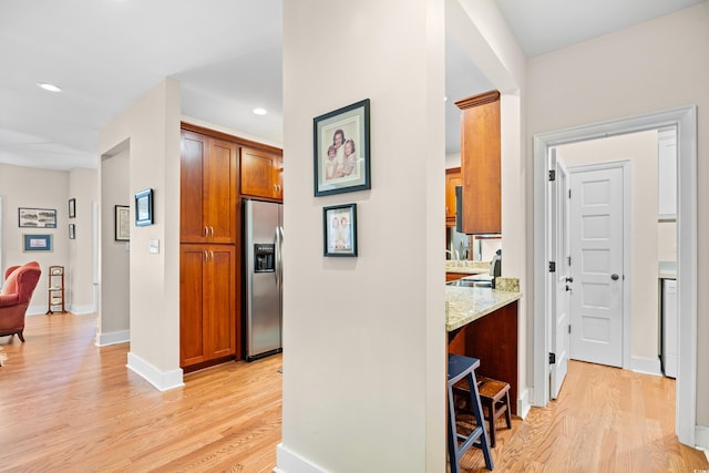 corridor with recessed lighting, light wood finished floors, and baseboards