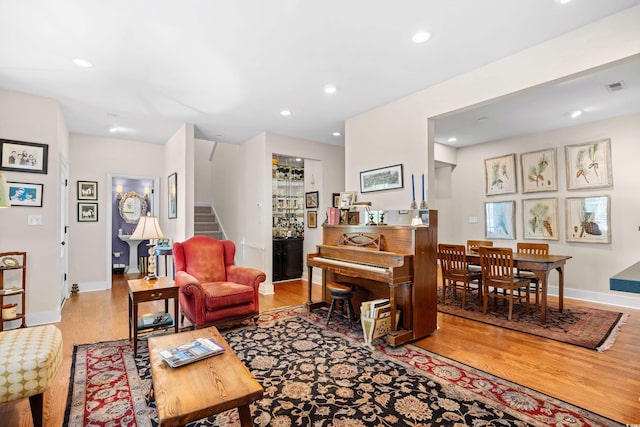 living room with baseboards, recessed lighting, stairway, visible vents, and wood finished floors