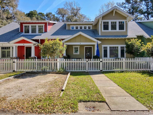view of front of house featuring a shingled roof and a fenced front yard