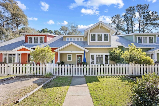view of front of home with roof with shingles and a fenced front yard