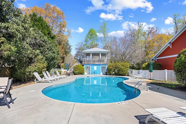 pool with a patio area and fence