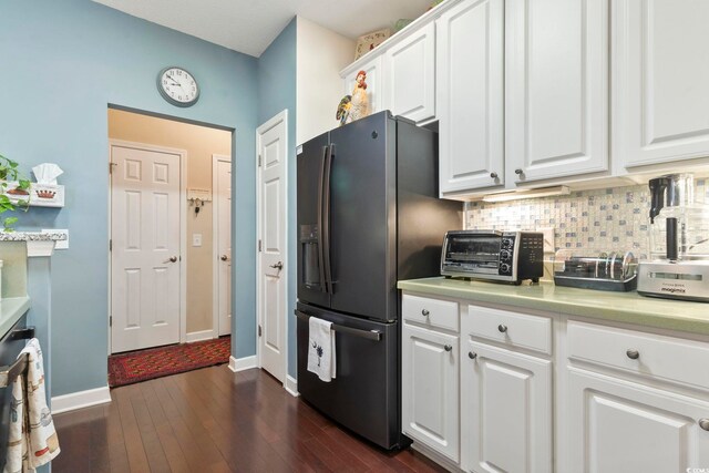 kitchen featuring decorative backsplash, a toaster, light countertops, white cabinets, and refrigerator with ice dispenser