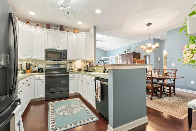 kitchen with stainless steel appliances, ceiling fan with notable chandelier, backsplash, a sink, and a peninsula
