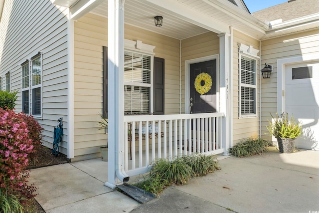doorway to property featuring covered porch and a garage
