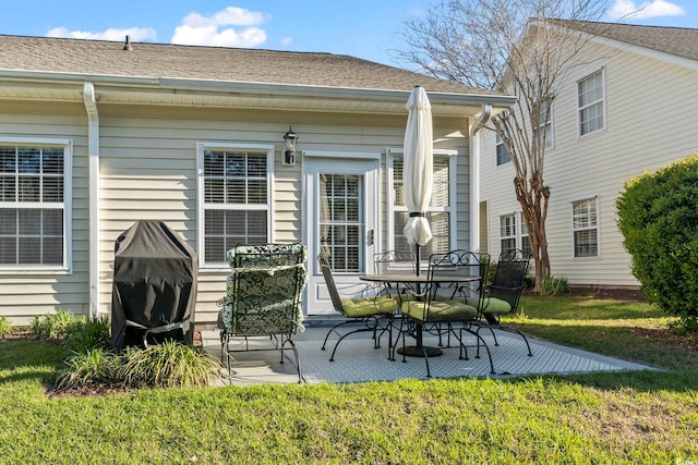 rear view of property featuring a patio, roof with shingles, and a lawn