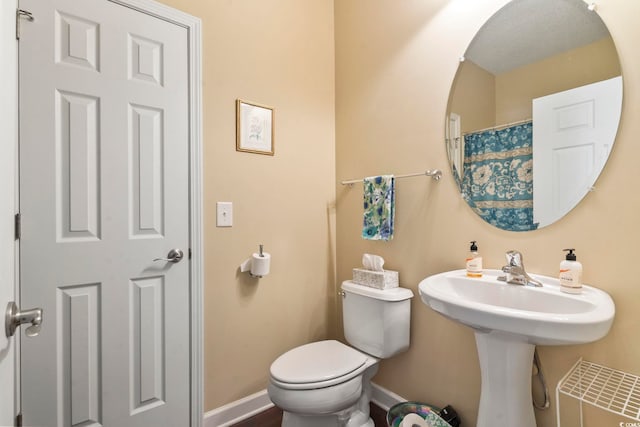 bathroom featuring toilet and baseboards