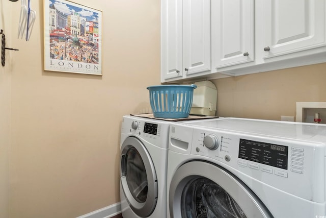laundry room with baseboards, washer and dryer, and cabinet space