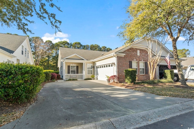 view of front of house featuring covered porch, concrete driveway, an attached garage, and brick siding