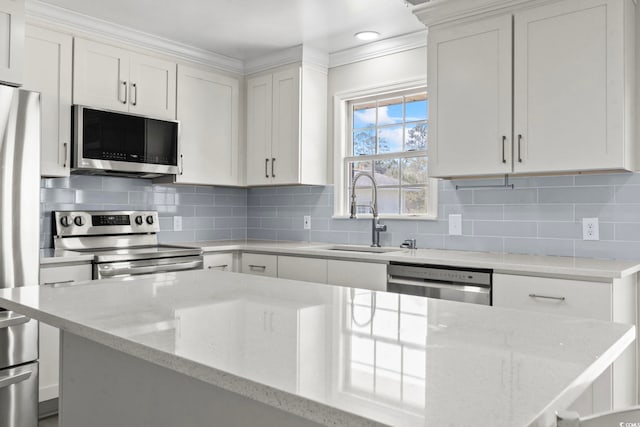 1136 Knotty Branch Rd, Conway, SC 29527 - kitchen with stainless steel appliances, a sink, white cabinets, light stone counters, and backsplash