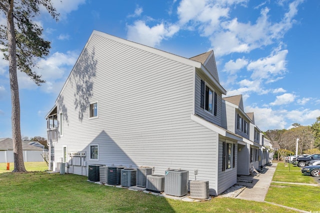 view of side of property with cooling unit and a yard