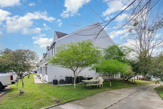 view of side of home with central air condition unit and a yard