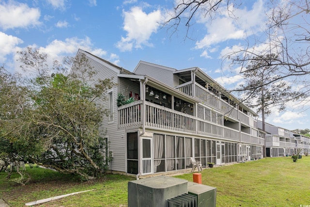 back of property featuring a balcony and a yard