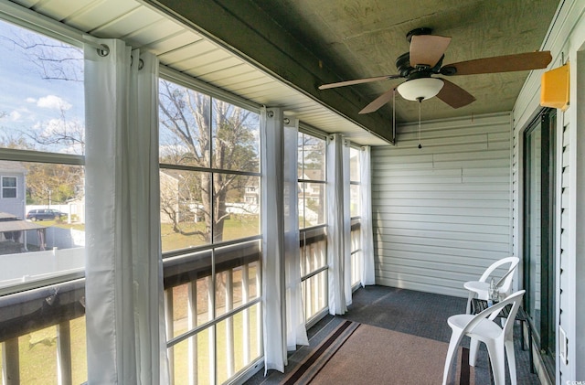 sunroom / solarium with a ceiling fan